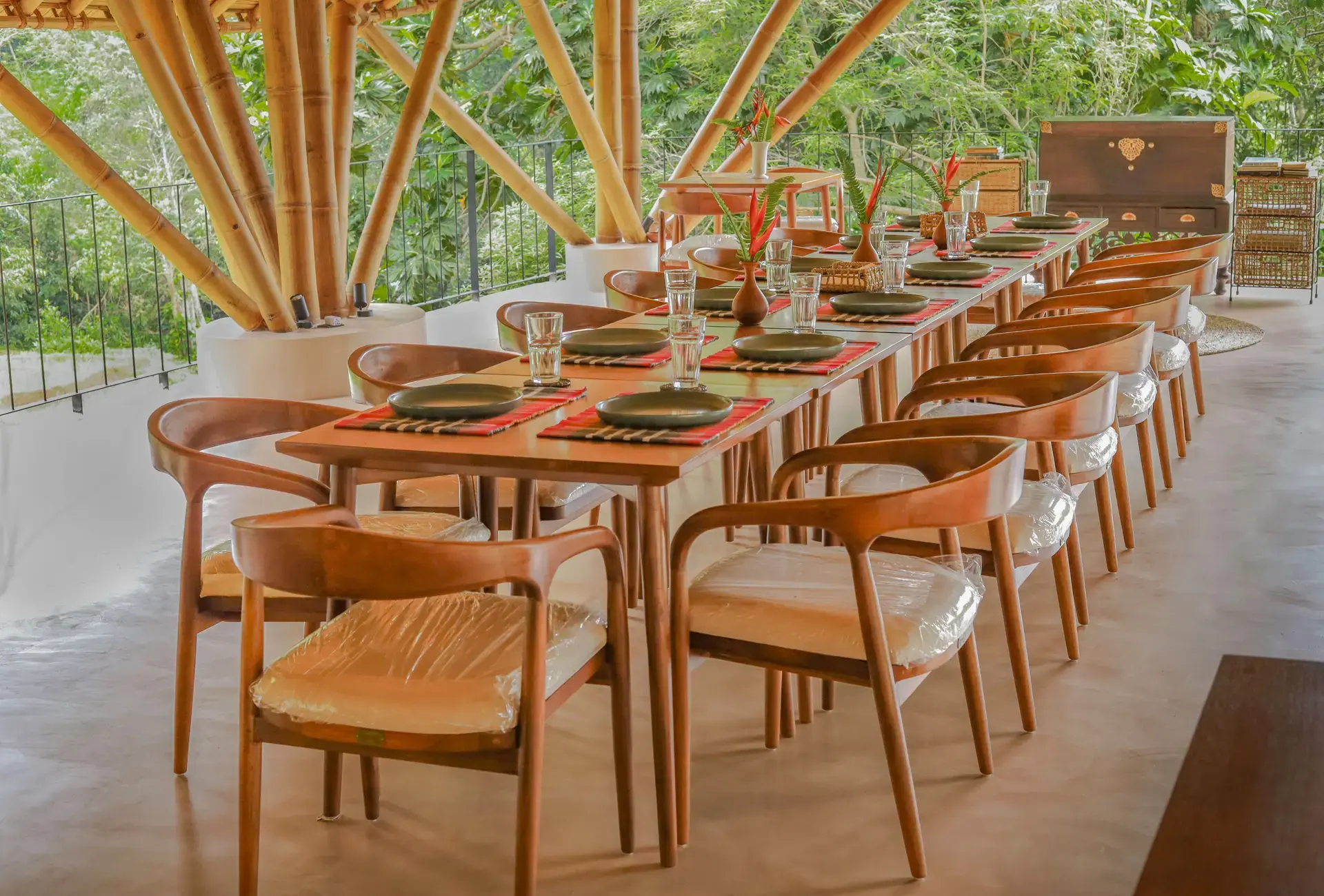 A long table laid for a meal under the bamboo roof