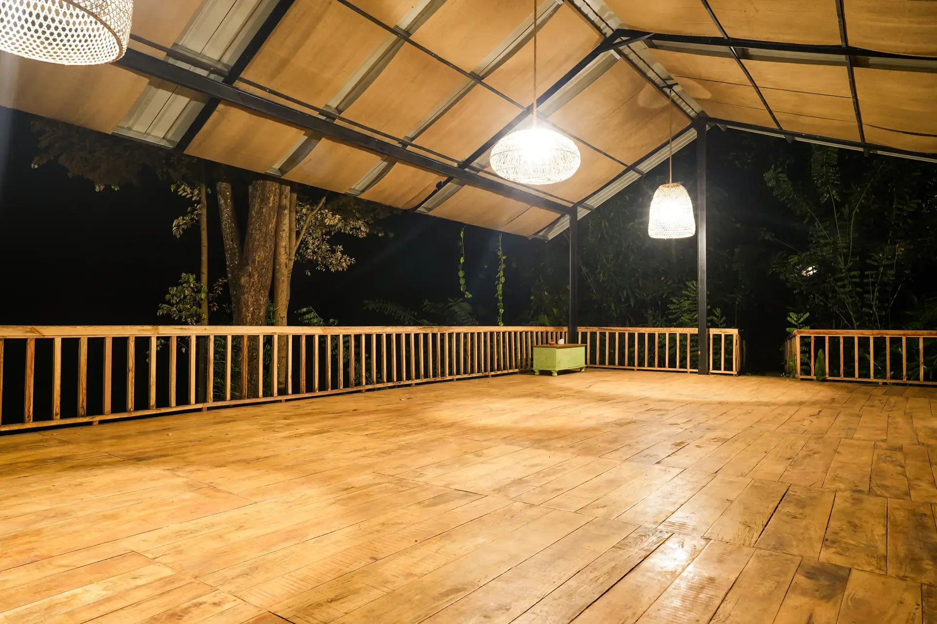 The yoga shala lit at night, surrounded by forest